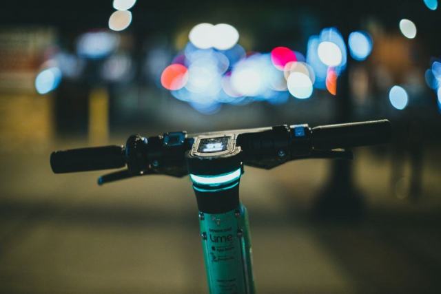 Trottinette électrique attachée par un antivol en U à un arceau de stationnement